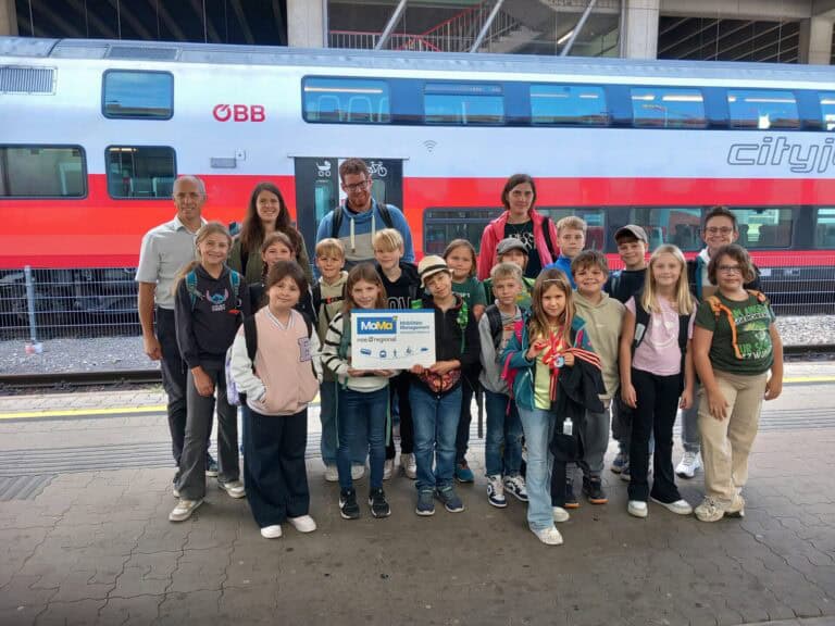 Kinder und Erwachsene stehen vor Zug am Bahnhof Krems an der Donau