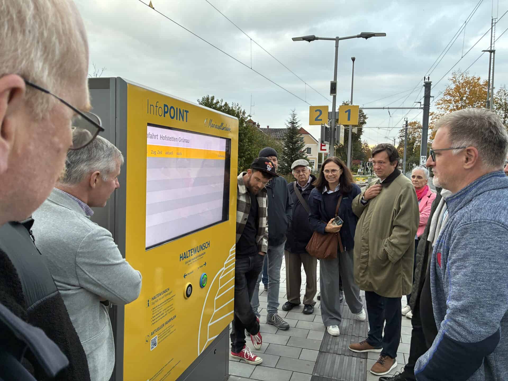 Menschen schauen Anzeigetafel am Bahnhof an