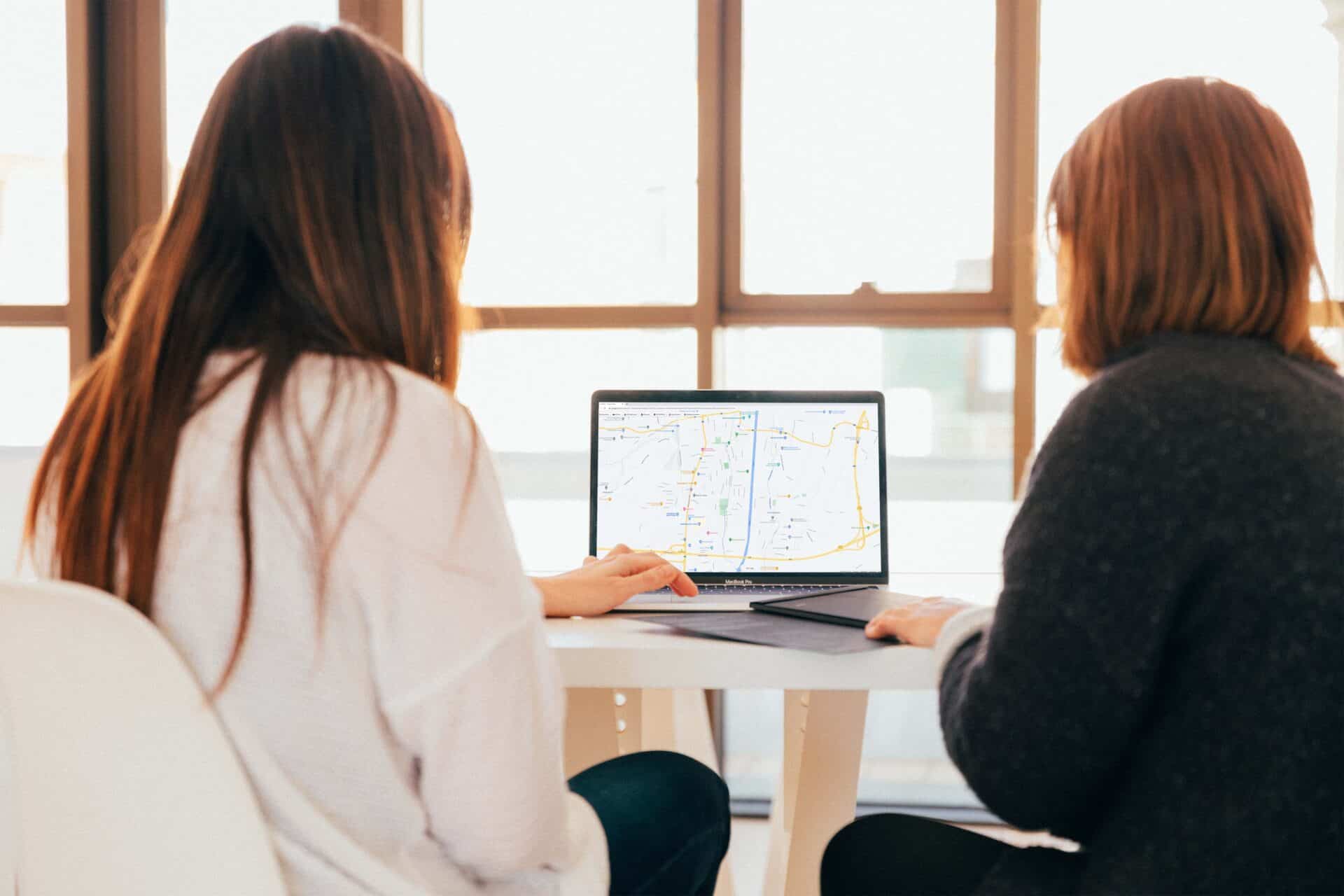 2 Personen mit Plan am Laptop
