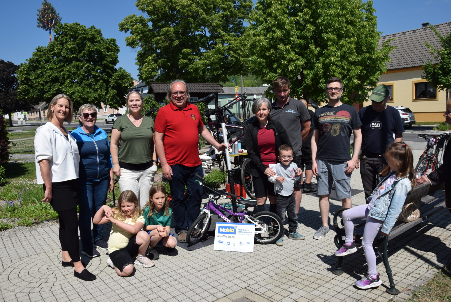 Gruppenbild mit 8 Erwachsenen und 4 Kindern mit Fahrrad Woom